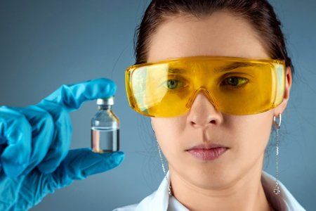 The girl is a doctor, scientist, laboratory assistant holding a bottle with a vaccine, medical...