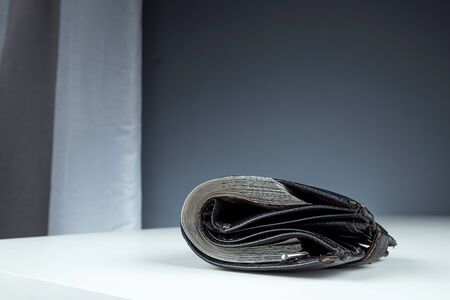 An old wallet full of money lies on a white table. Savings concept pension investment dividends passive incomeの写真素材