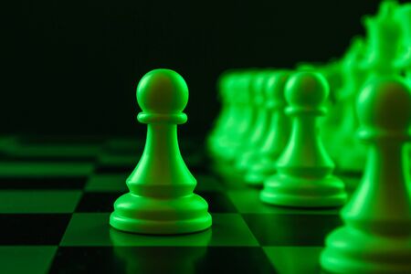 Close-up white pawn on a chessboard, chess, game. The concept of confrontation, career, promotion, startupの写真素材
