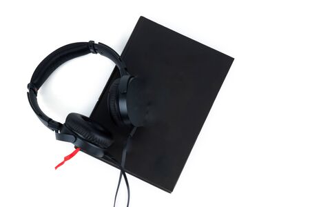 Black headphones and a book isolated on white background. Audiobook concept copy spaceの写真素材