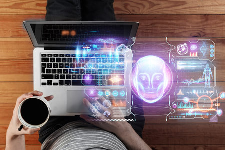 Top view of a man working on a laptop looking at a hologram with data, artificial intelligence, high...