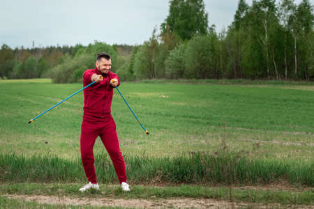 Sports, outdoor activities, Nordic walking, a man with sticks close-up. The concept of a healthy lifestyle, cardio training. Copyspaceの写真素材