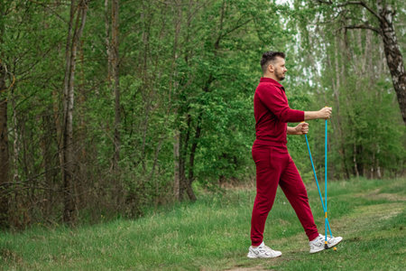 A man in a tracksuit is engaged in Nordic walking. The concept of a healthy lifestyle, cardio training. Copyspaceの写真素材