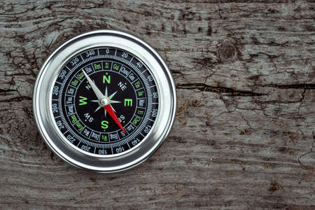 Silver compass on a wooden background top view. The concept of travel, leadership, help. Copy spaceの写真素材