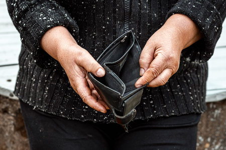 An empty wallet in the hands of a pensioner. Small pension concept, poverty