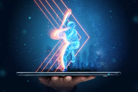 A silhouette, an image of a baseball player with a bat on fire crawls out of a smartphone, a hologram. Online sports concept, betting, American gameの写真素材
