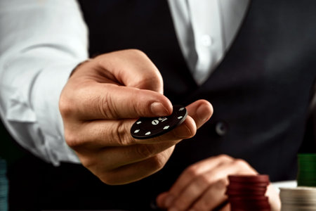 Male hands croupier in a casino and playing chips on a green cloth close-up. Casino concept,...