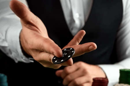 Male hands croupier in a casino and playing chips on a green cloth close-up. Casino concept, gambling, blackjackの写真素材