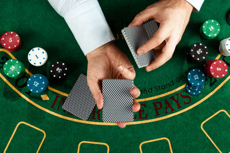 Male hands croupier shuffles cards close-up. Casino concept, gambling, blackjackの写真素材