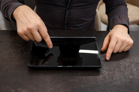 Male hands, finger pressing movements on a blank screen on a tablet. Concept businessman, office, financeの写真素材