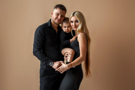Photo of a beautiful European married couple, a young girl and a guy with a little son, posing...