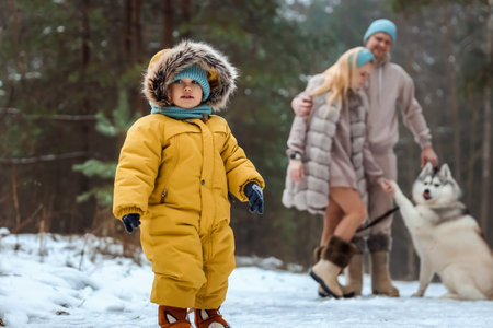 Happy family Dad, mom and baby sy on a winter walk in the forest. Concept for christmas, family, relatives, vacations, fresh airの写真素材