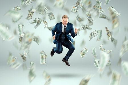 A man in a business suit jumps for joy against the background of falling dollars, rain of money....