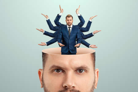 Instead of a brain, a man has a multi-armed businessman in his head. Creative picture, concept of multitasking, multi-hands, brain work, stress resistanceの写真素材