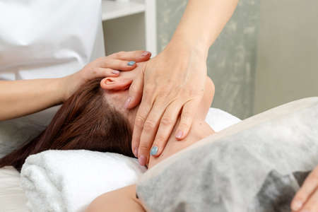 Neck massage close-up. Young, beautiful girl at spa procedures. Body care, oriental massage treatments, posture correction, beauty treatmentsの写真素材