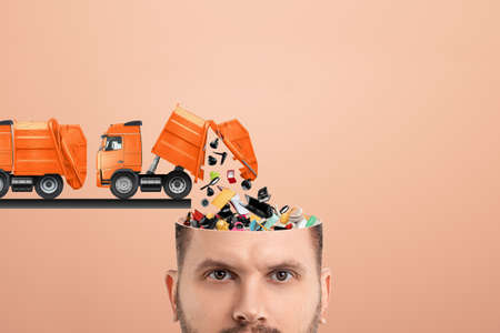 Garbage in the head, clogging up the head with unnecessary information. Garbage truck unloads garbage into the headの写真素材