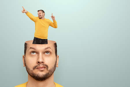 The man has little people dancing in his head. The concept of cheerful thoughts, euphoria, the brain rejoices, endorphins, axitocin and pleasureの写真素材