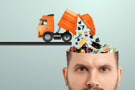 Garbage in the head, clogging up the head with unnecessary information. Garbage truck unloads garbage into the headの写真素材