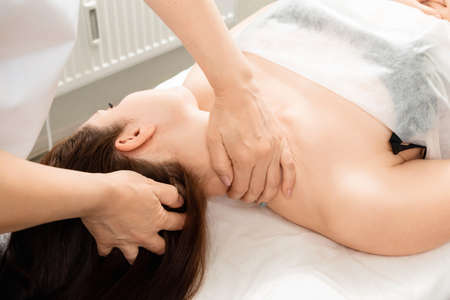 A beautiful girl is doing a neck massage. Skin care, beautician, spa treatments, relaxationの写真素材