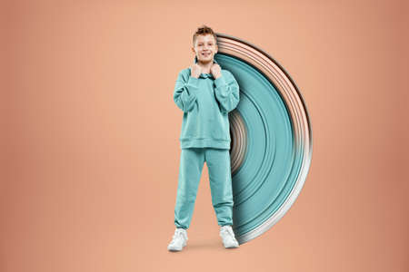Portrait, cute stylish boy in a blue suit on a beige background. Studio portrait of a child, modern design, trendy background, turquoise. Copy spaceの写真素材