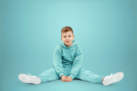 Portrait, cute stylish boy in a blue suit on a blue background. Studio portrait of a child, modern design, trendy background, turquoise. Copy spaceの写真素材