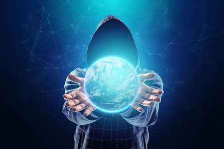 The planet earth is in the hands of a hacker, a man in a hood holds the world. Concept for world wide web, internet criminals, hacking, network attack, espionageの写真素材