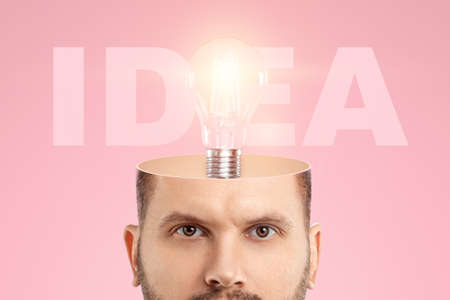 In the man's head, an incandescent lamp symbolizes an idea. The concept is a fresh look, a new idea, a creative solution, thinking outside the boxの写真素材