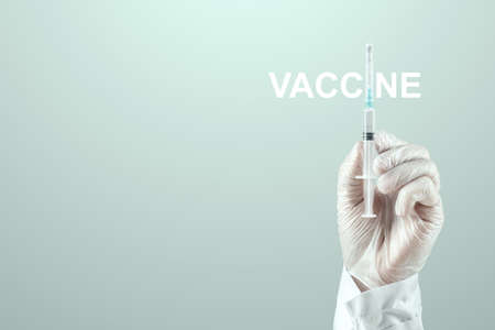 A doctor's gloved hand holds a syringe containing  vaccine. Medical research, close-upの写真素材