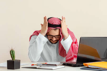 An Arab man, a businessman, a sheikh is tired of working. Investments, business, work via the Internet, online contractsの写真素材
