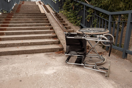 The concept of a wheelchair on the stairs turned over, disabled, full life, paralyzed. Problems for...