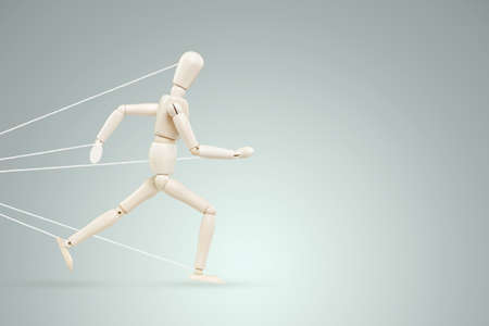 The neon marionette tied over the legs and arms fights and resists. Business difficulty or struggle with career obstacle concept, bureaucracy.の写真素材