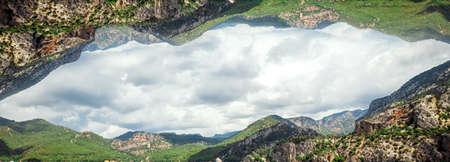 Creative landscape, modern design, mountains reflected in the sky, parallel worlds. copy spaceの写真素材