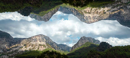 Creative landscape, modern design, mountains reflected in the sky, parallel worlds. copy spaceの写真素材