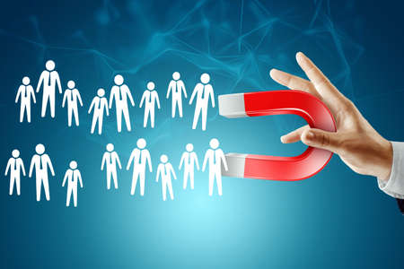A businessman with a magnet assembles a dream team. Recruiting employees, recruiting staff, hiring employeesの写真素材