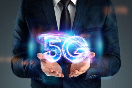 Over hand of businessman 5G hologram, creative background. 5G network concept, high speed mobile internet, new generation networks. Mixed mediaの写真素材