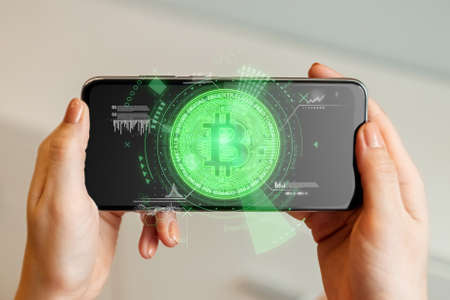 Creative background, bitcoin coin in a smartphone with analytics data, electronic money. Blockchain transfer concept, cryptocurrency, data encryption. Mixed mediaの写真素材