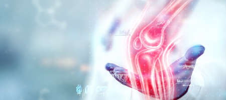 The doctor looks at a hologram of a sore knee, severe pain. X-ray image, trauma, rheumatologist consultation, skeletal image, medical concept, medical technologies of the future, pain when walkingの写真素材
