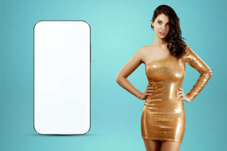 White screen smartphone mockup, environment to showcase mobile app design, creative background, smart phone for your advertisement. A creative girl stands next to a large smartphone. Copy spaceの写真素材