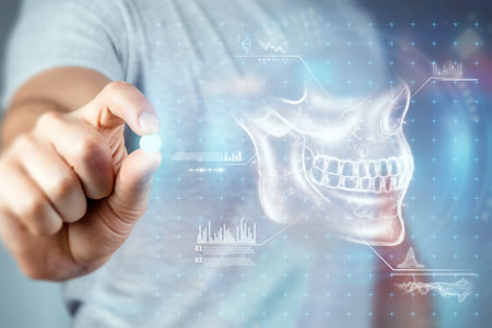 Close-up male hands holding a white pill, taking medication, treatment, gray background. Medical theme, vitamins, health careの写真素材