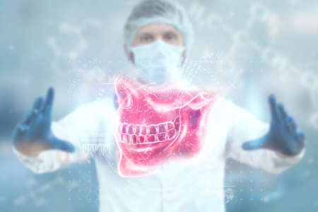Medical poster, human skull anatomy, jaw x-ray, teeth snapshot. The doctor looks at the x-ray hologram of the jaw. Dentist, orthodontist, toothache, biteの写真素材
