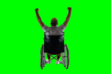 Silhouette of a disabled man in a wheelchair raised his hands. The concept of disability and illness, happiness, joy, successの写真素材