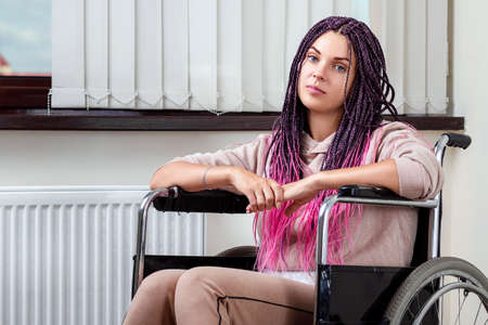 Beautiful modern disabled girl sitting in a wheelchairの写真素材