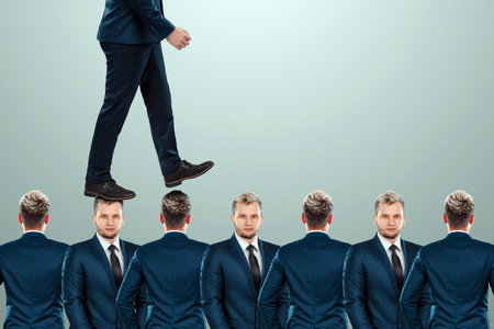 A man in a suit steps over the heads of employees. The concept of career growth, promotion, betrayal, careerの写真素材
