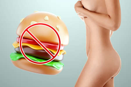 The figure of a young beautiful girl and a crossed out burger. The concept of healthy food, diet, sports, proper dietの写真素材