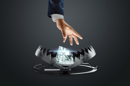 The male hand of a businessman reaches into a large golden bear trap. The concept of mortgage, dirty money, bribe, corruption, easy money, debt, credit. mixed mediaの写真素材