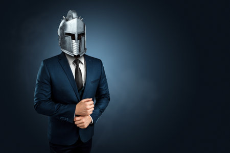 Creative image, a man in a modern suit of a businessman, a knight's helmet on his head, armor. The concept of a modern hero, overcoming difficulties, a crisis, a good manager. magazine style.の写真素材