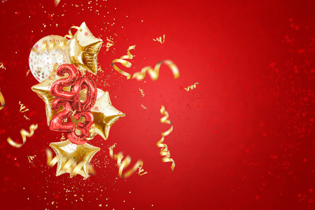 Happy new year 2023, golden inflatable balloons on a red background, confetti. Holiday card, magazine style, banner, website header, web poster, template for advertising. 3D illustration, 3D rendering.の写真素材