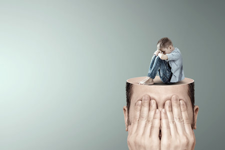 Stress, depression, emotional burnout. Malchi, the child sits with his head down on his knees, sad on a man's head. Unhappy, in a bad mood. Modern design, magazine styleの写真素材