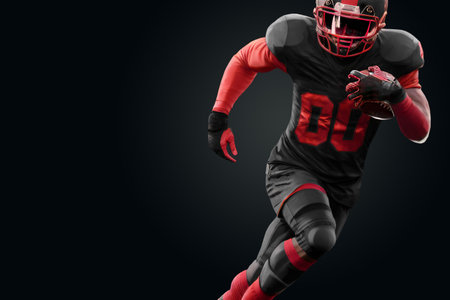 American Football player in red and black uniform in running pose on black background. American Football, advertising poster, template, blank, sports. 3D illustration, 3D renderingの写真素材