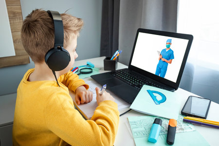 A teenager makes a videocall to her pediatrician while at home. The concept of online medicine, new technologies, modern possibilities of medicineの写真素材